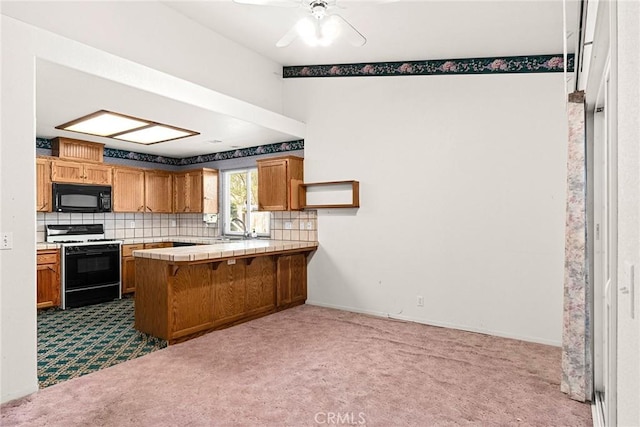 kitchen with black microwave, a peninsula, range with gas stovetop, decorative backsplash, and dark colored carpet