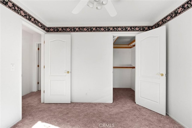 unfurnished bedroom with a closet, a ceiling fan, and carpet floors