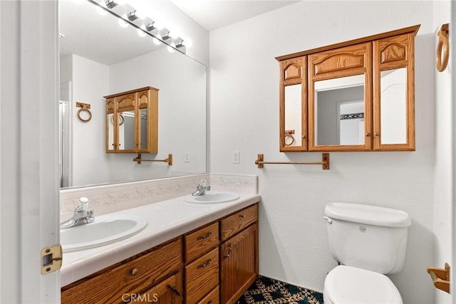 bathroom with toilet, double vanity, and a sink