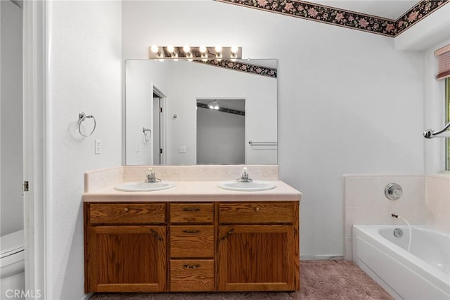 full bath with a sink, a bath, double vanity, and toilet