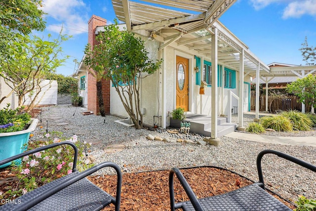 exterior space featuring stucco siding, fence private yard, and a pergola