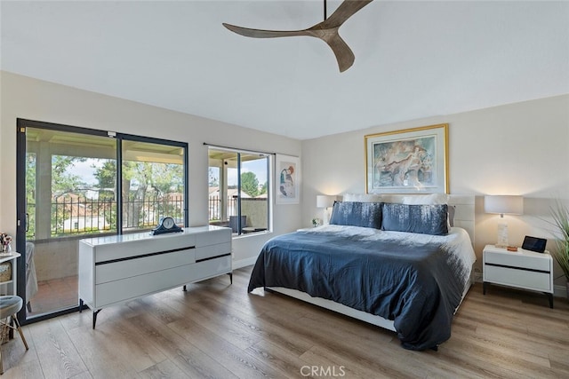 bedroom featuring ceiling fan, multiple windows, and wood finished floors