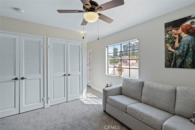living room with ceiling fan and carpet