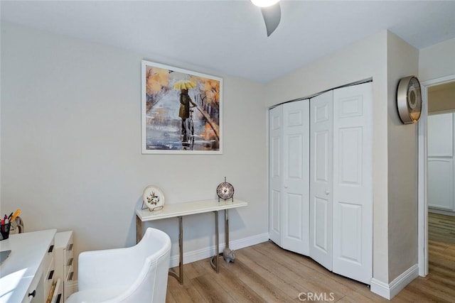 home office featuring baseboards, a ceiling fan, and light wood-type flooring
