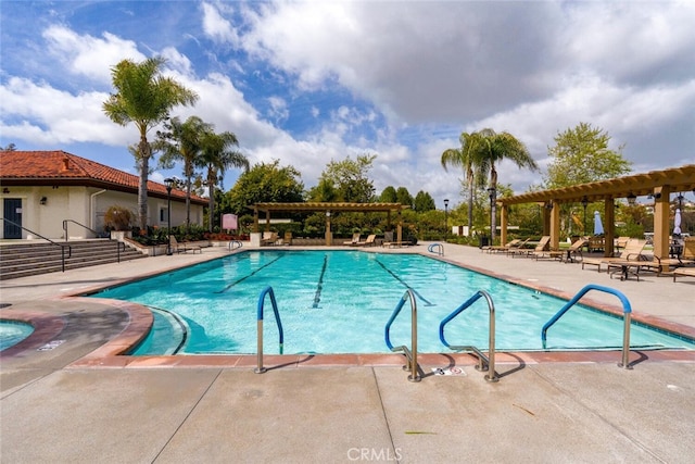 community pool with a pergola and a patio area