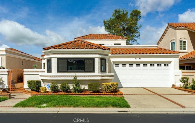 mediterranean / spanish-style house featuring concrete driveway, an attached garage, a gate, and a tile roof
