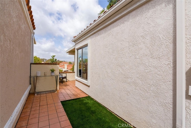 view of property exterior with stucco siding and a balcony