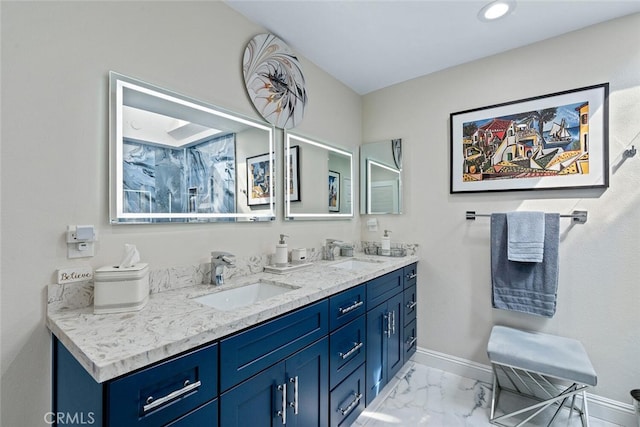 bathroom with double vanity, baseboards, a sink, and marble finish floor