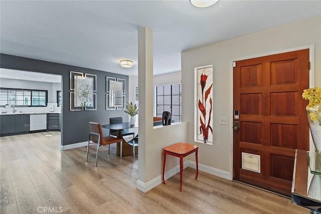 entrance foyer with baseboards and light wood-style floors