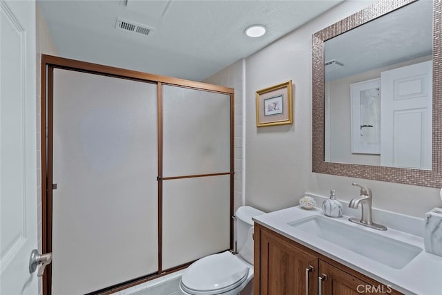 bathroom featuring vanity, a stall shower, toilet, and visible vents