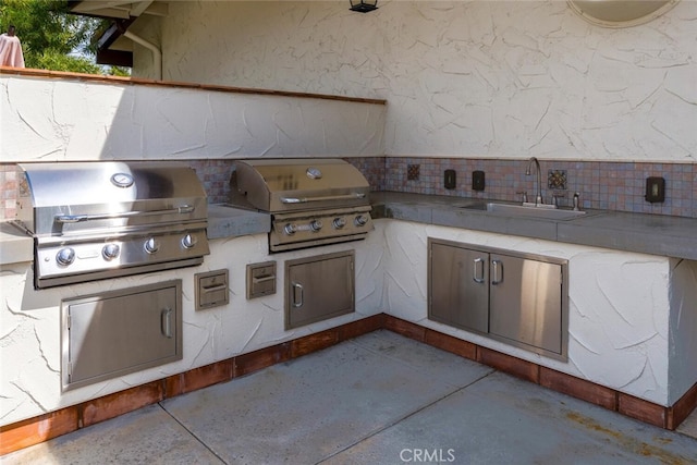 view of patio featuring grilling area, exterior kitchen, and a sink