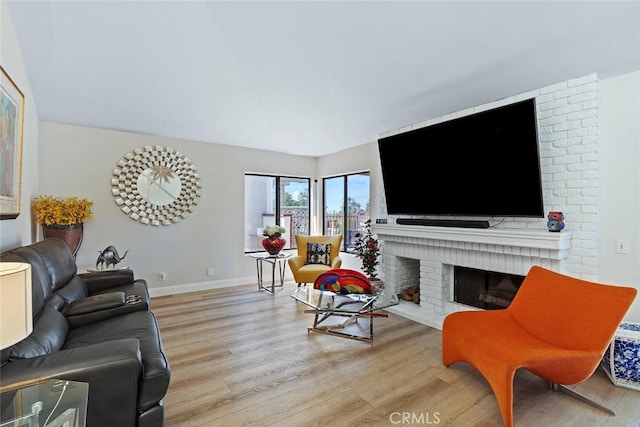 living area featuring baseboards, a fireplace, and light wood-style flooring