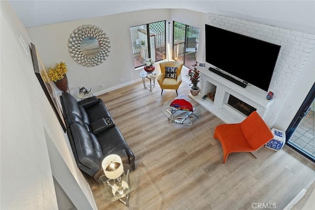 living room featuring baseboards, vaulted ceiling, and wood finished floors