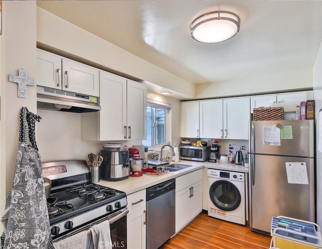 kitchen featuring washer / clothes dryer, light countertops, white cabinets, under cabinet range hood, and appliances with stainless steel finishes