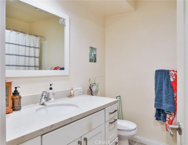 bathroom featuring a shower with curtain, toilet, vanity, and baseboards