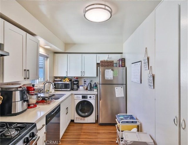 kitchen featuring stainless steel appliances, washer / clothes dryer, white cabinets, and light countertops