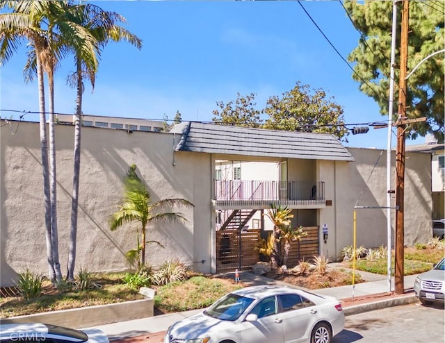 view of front facade featuring stairs and stucco siding
