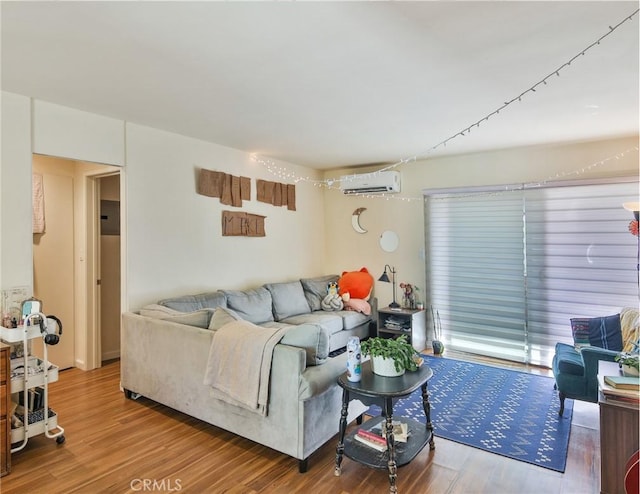 living area featuring a wall mounted AC and wood finished floors