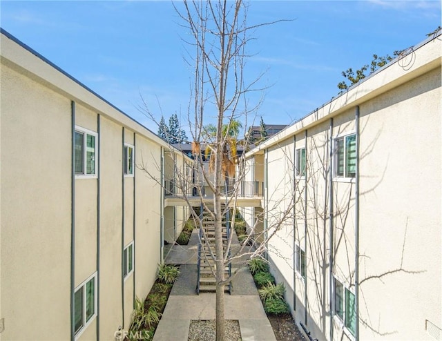 exterior space featuring stucco siding and stairs