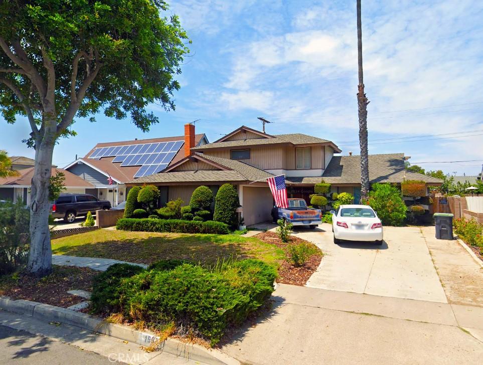 traditional home with driveway, a chimney, an attached garage, and fence