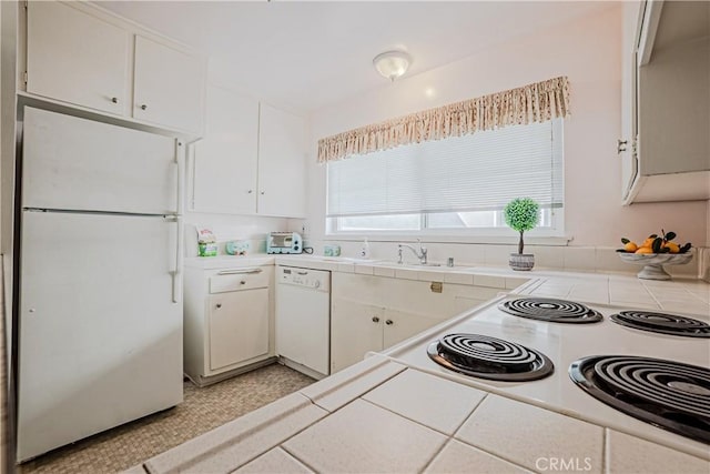 kitchen featuring a sink, white appliances, tile counters, and white cabinetry