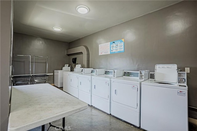 common laundry area featuring arched walkways and independent washer and dryer