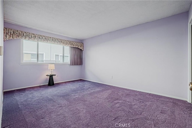 empty room featuring carpet flooring and baseboards