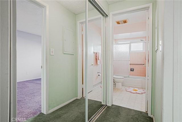 hallway with carpet flooring, baseboards, and visible vents