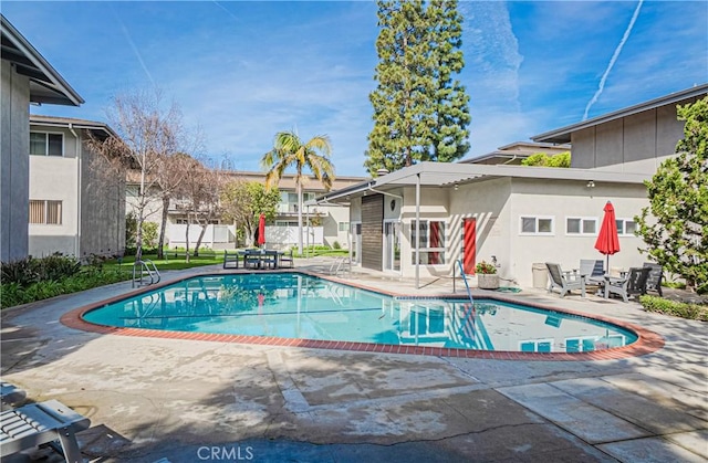 view of swimming pool with a patio area, a residential view, a fenced in pool, and fence