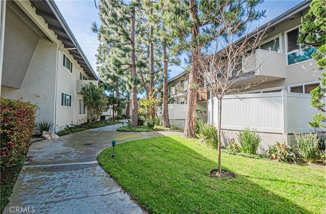 view of property's community with a yard and fence