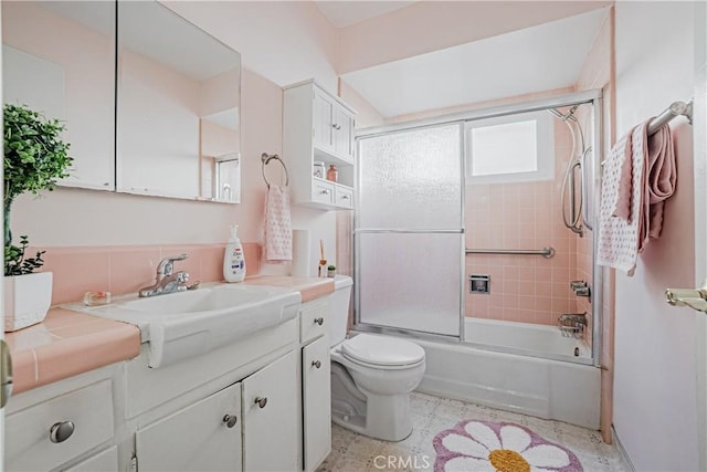 bathroom with shower / bath combination with glass door, toilet, and vanity