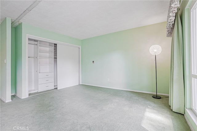 unfurnished bedroom featuring a closet, carpet floors, and baseboards