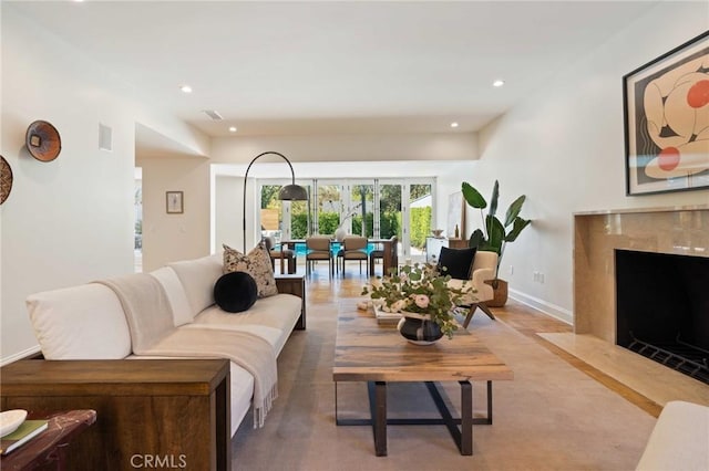 living room featuring a high end fireplace, visible vents, recessed lighting, and baseboards