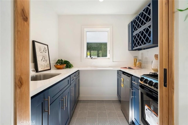 kitchen with a sink, blue cabinets, gas range, and light countertops