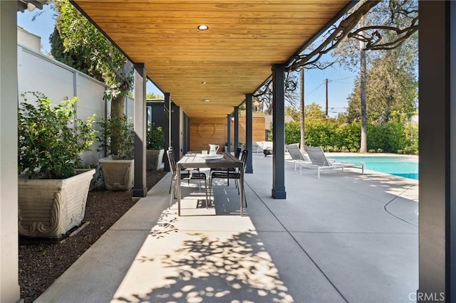 view of patio / terrace with an outdoor pool and fence