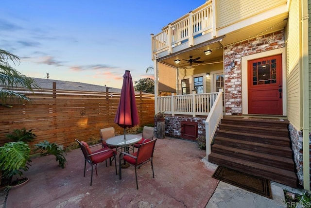 view of patio / terrace with outdoor dining space, ceiling fan, a fenced backyard, and a balcony