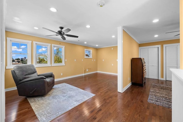 living area featuring crown molding, ceiling fan, baseboards, recessed lighting, and dark wood finished floors
