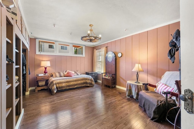bedroom featuring an inviting chandelier, hardwood / wood-style floors, and crown molding