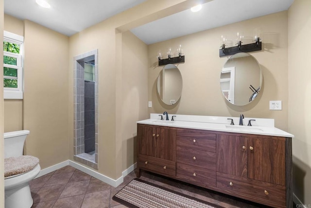 full bathroom featuring toilet, double vanity, a sink, and baseboards
