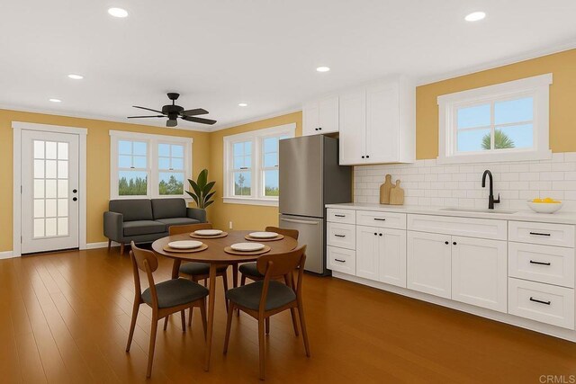 kitchen with a sink, ceiling fan, light countertops, freestanding refrigerator, and recessed lighting