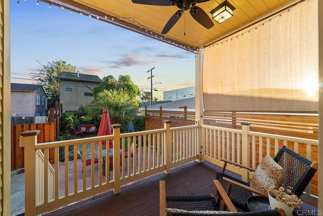 view of wooden balcony with a deck and ceiling fan