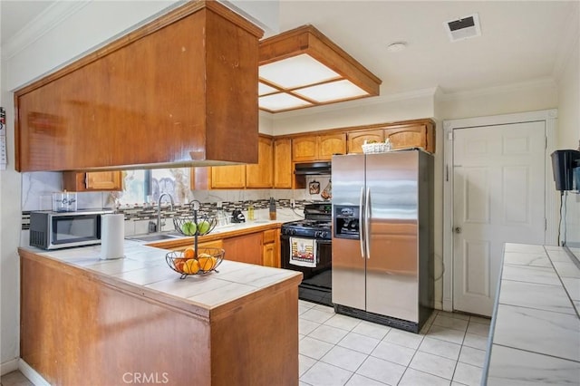 kitchen featuring visible vents, a peninsula, a sink, stainless steel appliances, and under cabinet range hood