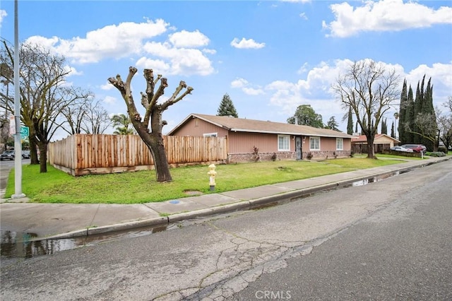 single story home featuring a front lawn and fence