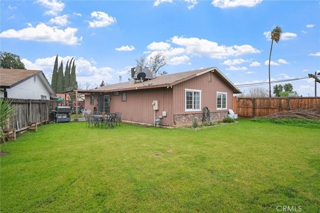 back of property with central AC unit, a yard, a fenced backyard, and brick siding