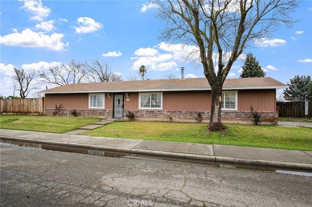 single story home featuring brick siding, a front lawn, and fence