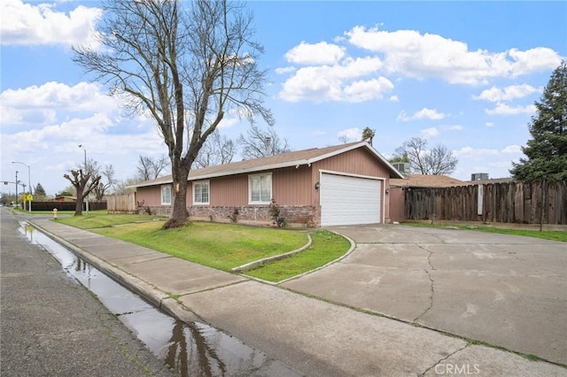 single story home with brick siding, fence, concrete driveway, a front yard, and a garage