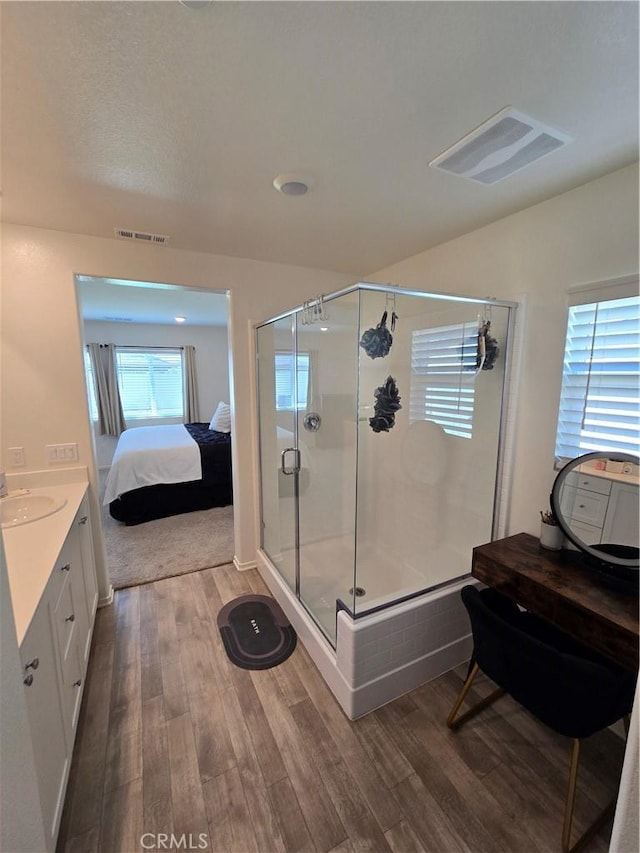 ensuite bathroom featuring visible vents, ensuite bathroom, and wood finished floors