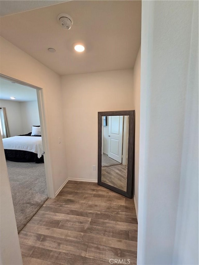 hallway with baseboards and wood finished floors