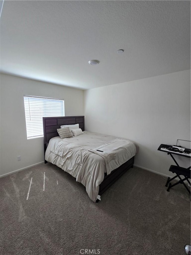 carpeted bedroom with baseboards and a textured ceiling