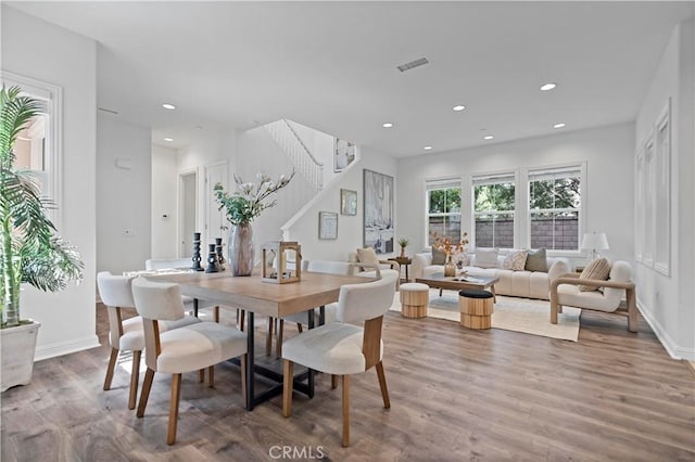 dining room featuring visible vents, baseboards, stairs, wood finished floors, and recessed lighting